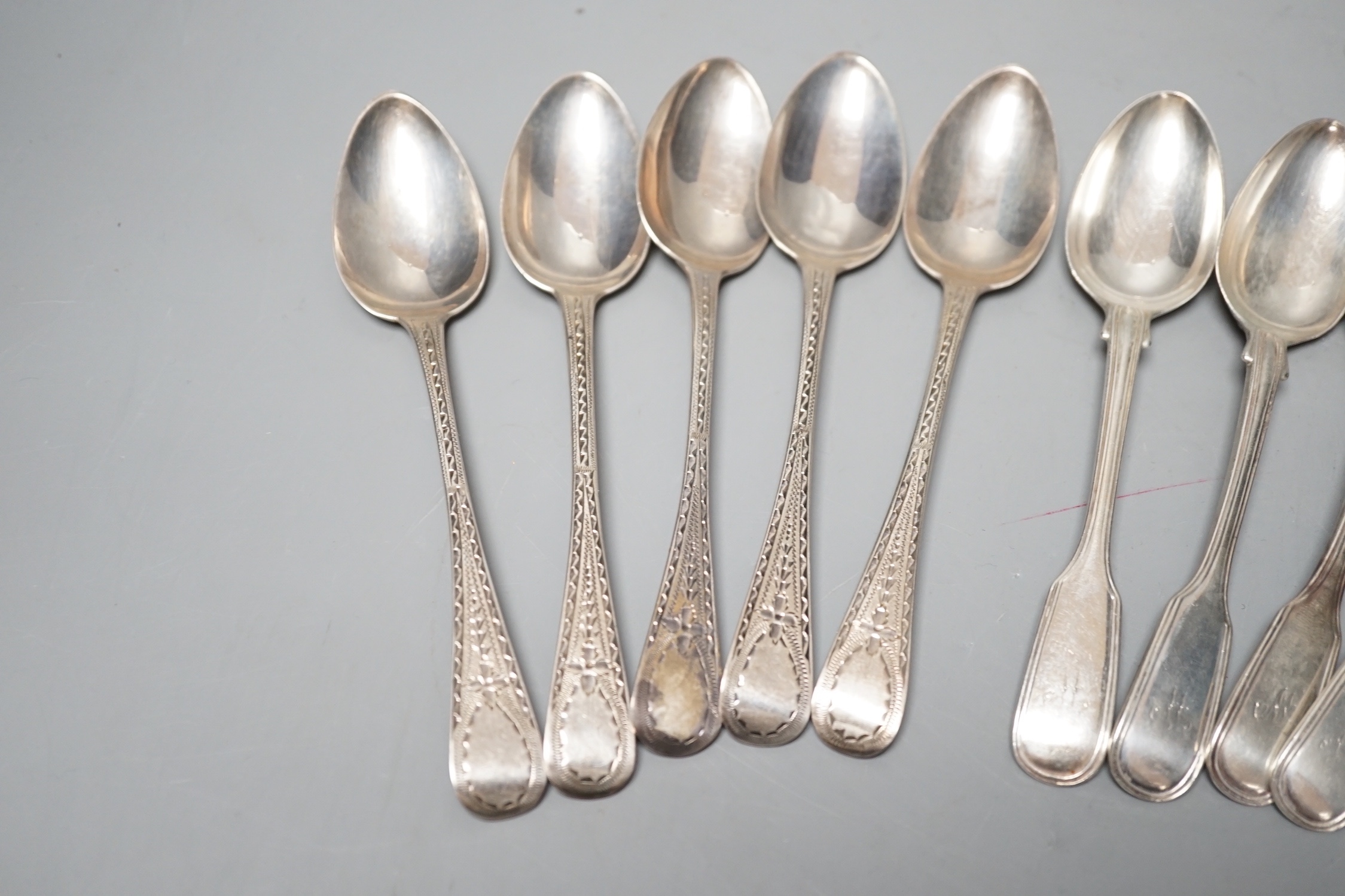 A set of six Victorian silver fiddle and thread pattern teaspoons, London, 1853 and a matched set of six Victorian silver bright cut engraved Old English pattern teaspoons, 9oz.